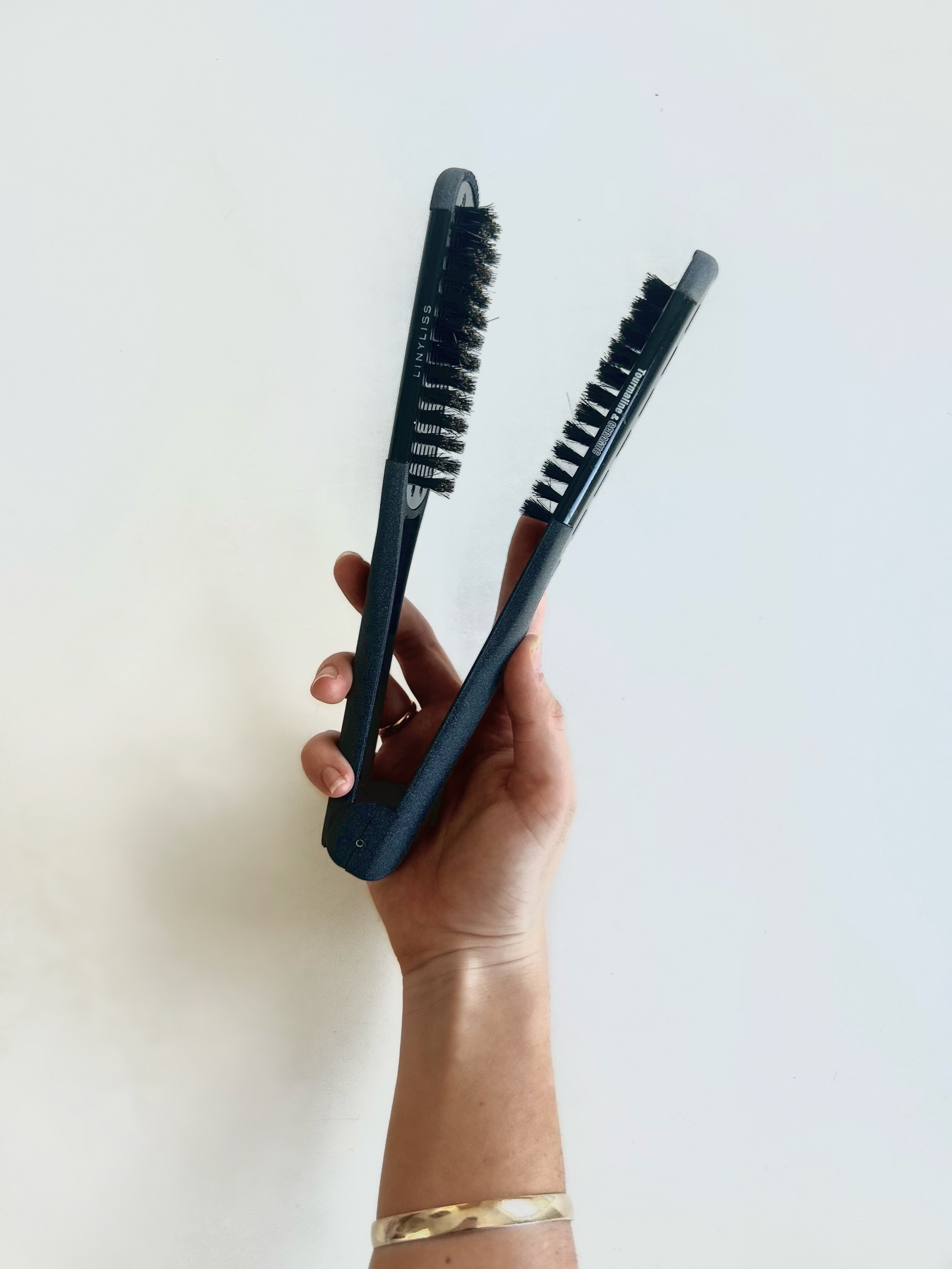 double-sided straightening brush with black bristles and barrels.